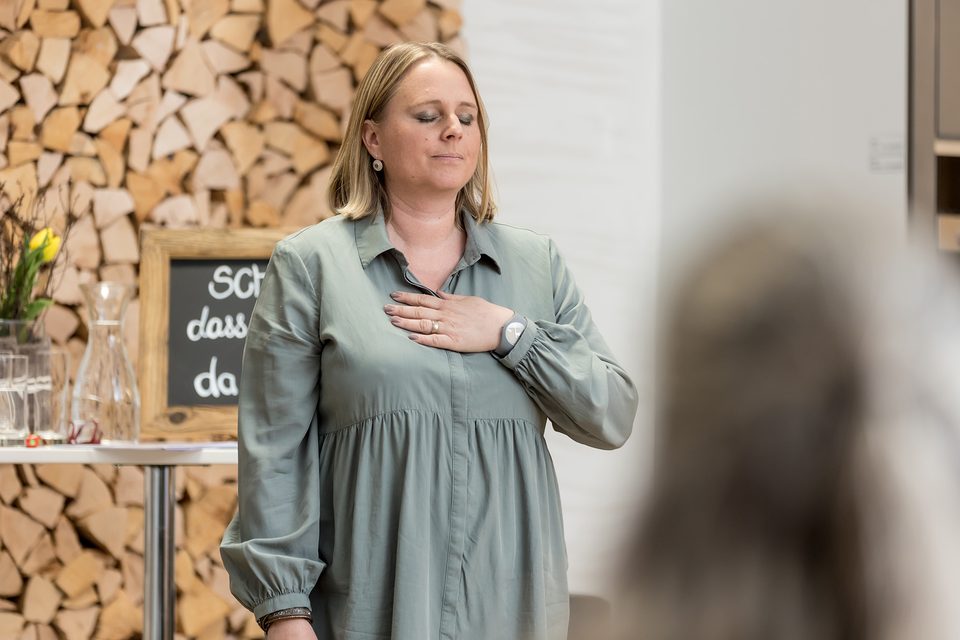 Nicole Gansner leitet eine Meditation an der Herztankstelle in Zizers – Hand auf dem Herzen, Augen geschlossen